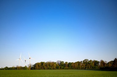 Rüzgar türbinleri, doğa ağaçları ve saha fotokopi alanı olan güzel bir yaz manzarası. Yüksek kalite fotoğraf