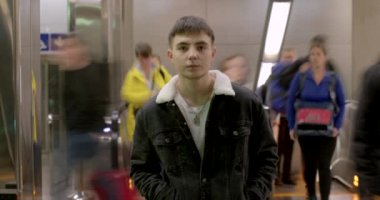 Adam kameraya hareketsiz bir şekilde bakıyor. Arka planda insan trafiği. Erkek, genç. Yüksek kalite 4K görüntü. CZ, Prag, Republici, 1.10.22