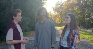 Portrait communicating young people. Two boys talking girl park. Effective communication in love triangle, relationship which three people. Romance of student life. 9.10.22. CZ, Prague, Stromovka