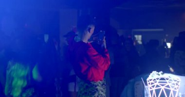 The guy makes a photo in a nightclub. Create an online blog at the party. Photo transfer using mobile internet. CZ, Prague, Republici, 30.10.22