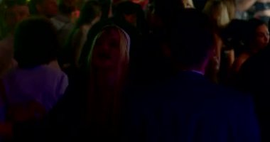 A girl in a nun costume does a dance on the dance floor in a nightclub. She claps her hands, joy. Blue light. CZ, Prague, Republici, 30.10.22