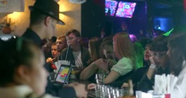 Bar work at a party. The bartender pours a drink into glasses for visitors in bokeh. Party atmosphere. CZ, Prague, Republici, 30.10.22