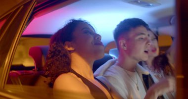 The movement of the car in the night tunnel. In the cockpit, the guy sings a song, gesticulates with his hands, high spirits on his birthday. Red lips lipstick.