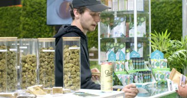 Seller of cbd cannabis shows a gesture of approval of the choice, smiles at a buyer during a successful transaction. Business communication and sales. Good deal. 5.11.2022 Letnany, Prague, CZ 