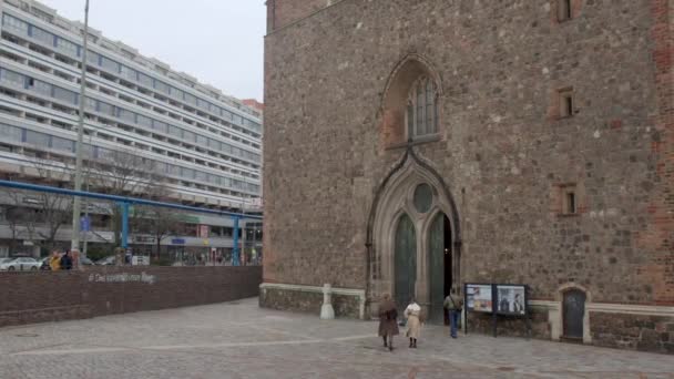 Люди Входят Здание Церкви Маленькая Дверь Высокой Стене Городская Улица — стоковое видео