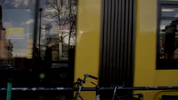 市内の黄色のトラムの動き 地域間の乗客の輸送 ライトガラスの建物のグレア タクシー駐車場 Berlin Friedrice 2023 — ストック動画