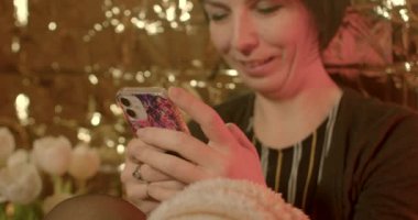 A woman uses the phone in the evening, she looks at the screen and smiles. Receiving and exchanging emotions using the WIFI high-speed Internet messenger.
