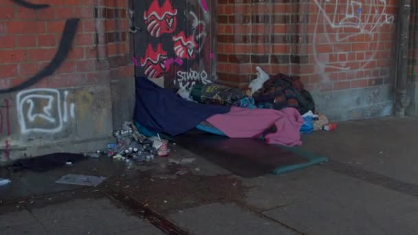 一个流浪汉躺在毯子里睡觉的地方 它就在墙边街道的拐角处 附近的酒瓶 人行横道 人行横道 Berlin Friedrich 2023 — 图库视频影像