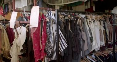 Warehouse in the dressing room. Items hang on hangers, a piece of paper signed for the worker. Clothing performs aesthetic functions - it creates the image of a person. CZ, Prague, Studulki 9.10.22