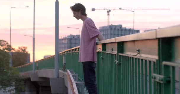 Guy Stands Bridge Holds Handrail His Hands Looks Straightens His — Video