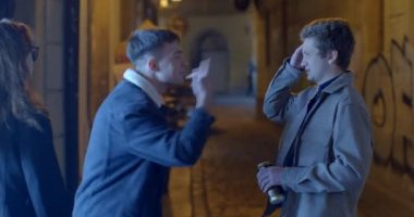 Sokaktaki adam adamı itiyor ve küfür ediyor. Duygusal olarak konuşur, küfreder, akşam sokakta ellerini sallar. O, eliyle bir kutu içki aldı. CZ, Prag, Karlova, 1.10.22
