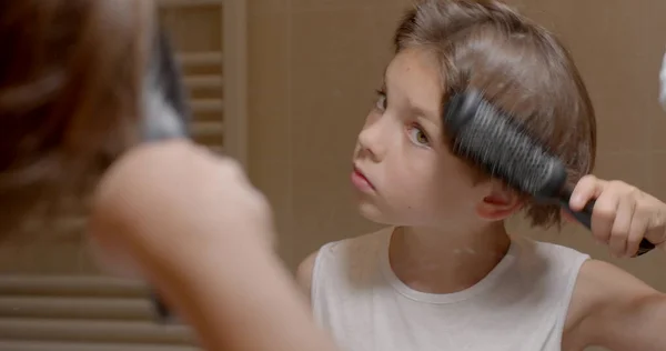 Αγόρι Χτενίζει Μαλλιά Του Στον Καθρέφτη Κρατάει Μια Χτένα Χέρι Φωτογραφία Αρχείου