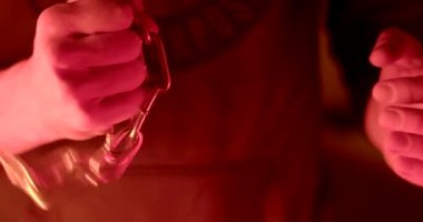 The hand winds the chain around the fist, ready for a street fight. Flashing light red and blue. Demonstration of open aggressive behavior. Unfastens the carabiner with his hand.