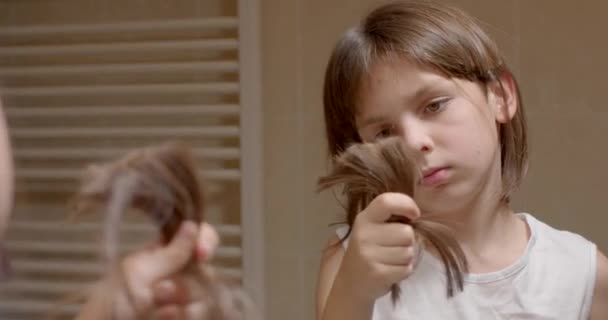 Uzun Saçlı Bir Çocuk Elinde Bir Tutam Saç Tutuyor Aşağı — Stok video