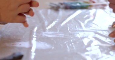 Çocuk elleri, kilin modellenmesinde tekrarlanan hareketler yaptı. Ukraynalı mültecilerle sanat terapisi seansı. Özel ihtiyaçları olan çocuklarda iyi motor becerilerin gelişimi.