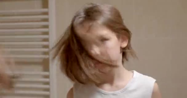 鏡の中の頭と髪の急速な動き 少年はバスルームで朝に髪を毛で覆っている 新しい一日の動機 ホワイトTシャツボディ — ストック動画