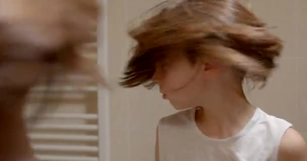 Мальчик Смотрит Себя Зеркало Поворачивает Голову Развивая Длинные Волосы Помогая — стоковое видео