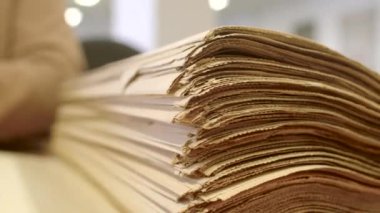 Bir yığın eski gizli arşiv belgesinin yakın çekimi. Bir arşivci ya da tarihçi, arşiv belgelerini sararmış eski sayfaları çevirerek inceler. Miras almak için aile soruşturması.