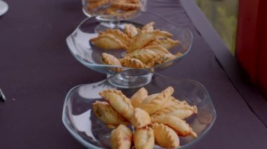 Kahve molası, dinlenmek ve atıştırmalık da dahil olmak üzere dinlenmek için çalışmayı bıraktığınız kısa bir zamandır. Cam bir tabaktan turta alan bir elin yakın çekimi.