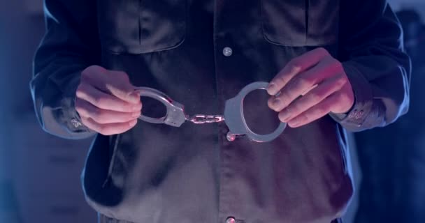 警察官の手の近くに彼の指に手錠を保持する 彼は金属製の手作り道具を実演している 任意降伏 恩赦を提供する — ストック動画
