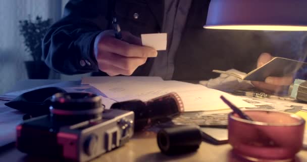 检查秘密警察的桌子上的文件 这只手在桌上写字 香烟烟灰缸 文件中信息的积累和检索 — 图库视频影像