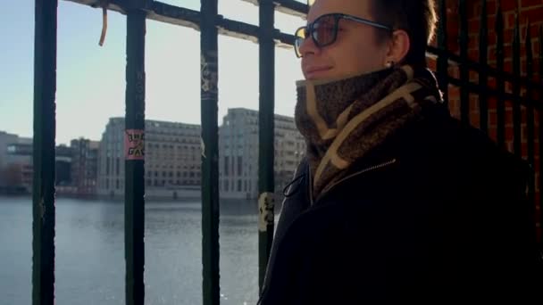 一个人在金属栅栏附近的画像 阳光透过金属棒照射 水面上闪烁着光芒 等待一个会议 内部推理 Berlin Mitte — 图库视频影像