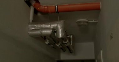 Evin bodrumundaki tavanda borular var. Mavi ve kırmızı yanıp sönen ışıklar, alarmda yanıp sönen ışıklar, dikkat çekiyor. Isıtıcıyı odaya taşıma elementi.