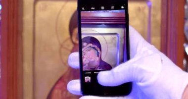 Telefonla en yüksek görüntü kalitesi ve çözünürlüğü olan fotoğraflar çek. İkonun üzerinde tasvir edilen detayların ve sembollerin kopyalarını yapan bir din bilgininin ellerine yakın çekim. 