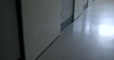 Kapının köşesi ve odanın katı insanları izole ediyor. Kamera karanlıktan aydınlığa hareket ediyor. Zemin boyasının yüzeyindeki ışığın yansıması..