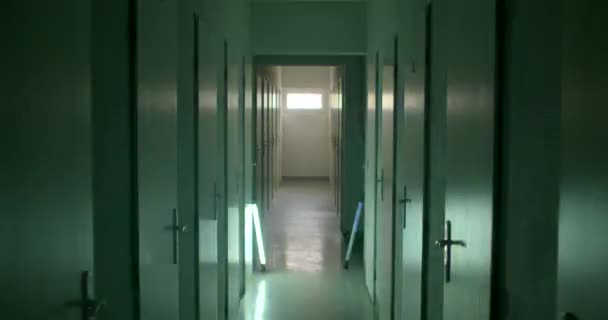 刑務所の中の光警報壁に閉じられたドアの列 床と車のアラーム 脱獄の壁に光のグレア カメラの動き — ストック動画