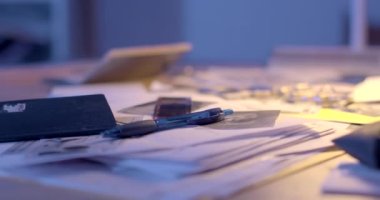 Müfettişlerin eşyaları masada. Yumuşak odaklı, masada kamera var. Kamera hareketi. Gizli bir polis memurunun masası. Bokeh 'teki belge kamerası, kelepçe yüzeyi.