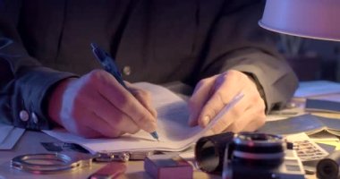 Gizli polisin elleri, bilgi toplayan belgeleri inceliyor. Masanın üzerindeki kağıda elle yazılmış bir not bırakıyor. Soruşturma için veri analizi. CZ, Kladno, Polska, 8.3.23