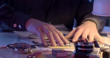 Soruşturma masasında kayıp bir eşyayı arayın. Kelepçe buluyor. O, ellerini masanın üzerinde hareket ettirir. CZ, Kladno, Polska, 8.3.23