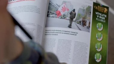 Kullanıcı elinde bir kurşun kalemle derginin yanında yazı ve resim basmış. Kanada bayrağı, yasallaştırma. Bilgi araştırması. 25.02.2023 Rackunai. Litvanya