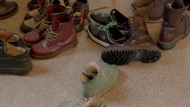 许多双鞋子在地板上群策群力 多种颜色的鞋带和鞋带 鞋子堆积起来的地方走廊令人不快的脚臭2023年2月25日立陶宛 — 图库视频影像