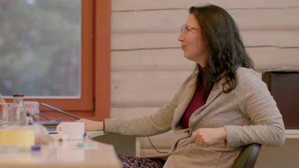 在他的地方教书会讲信息 戴眼镜的女人用椅子和桌子说话 她说话和做手势 桌上的物品在Bokeh 2023年2月25日立陶宛 — 图库视频影像