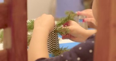 Çocukların elleri kağıt bardakta Noel ağacı dalı yapıyor. Eşyayı elinde tutuyor, zihinsel olarak iyileşiyor ve DIY sanatı yapıyor..