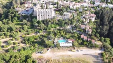 Şehirle birlikte dağlarda manzaralar. Ağaçların ve çimenlerin yeşilliğinde evler ve bahçeler. Uzun bitkiler. Hiçliğin ortasında bir vaha..