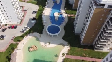 Konut kompleksi havuz bölgesi. Uzun evlerin birçok kiralık dairesi vardır. Bölgenin gölgesi, dinlenmek için rahat bir yer.. 