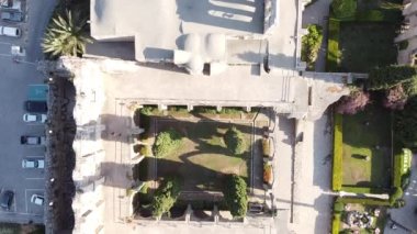 Şehirdeki bir binanın üst manzarası. Ağaçlı bölge. Beton çatı rahatlatıyor. Bölgede peyzaj. Araba park etme, işaretleme.