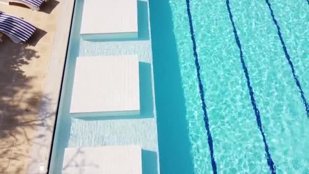 수영장 가장자리의 파란색은 수영하는 사람들을 부문으로 부분에 줄무늬가 해변에 라운지 — 비디오