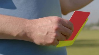 Ciddi ihlallerin cezası kırmızı ve sarı kart ihlalleri için verilir. Kartları tutan hakemin yakın çekimi..