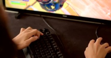 Bir oyuncu oyuna tamamen dalmış bir klavye ve fare kullanarak bir bilgisayar üzerinde çalmaya konsantre olur