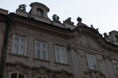 Çok sayıda penceresi olan ve gökyüzündeki genel yapısının bir parçası olarak iyi tanımlanmış bir çatıya sahip büyük bir bina.