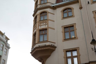 Çok sayıda penceresi olan geniş ve geniş bir bina ve aynı zamanda açık hava aktiviteleri için şık bir balkon içerir.