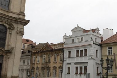 Arka planda güzel bir şekilde yerleştirilmiş görkemli bir kilisenin bulunduğu büyüleyici binalar dizisi güzel bir şehir manzarası yaratıyor.