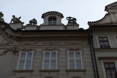 Sayısız pencereyle karakterize edilmiş etkileyici bir yapı ve çatısı üzerinde zarif bir şekilde duran güzel heykellerle süslenmiş.