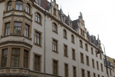 Önemli sayıda pencereye sahip ve üzerinde belirgin kırmızı bir çatı bulunan geniş ve büyük bir bina vardır.