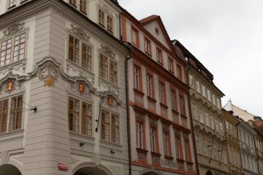 Kalabalık mahallede, üzerinde parlak kırmızı bir tabela bulunan ve dikkat çeken bir bina var.