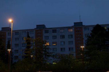 Çok sayıda pencereye sahip büyük bir bina gece saatlerinde güzelce aydınlatılır ve çarpıcı bir görsel etki yaratır.